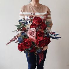 a woman holding a large bouquet of flowers