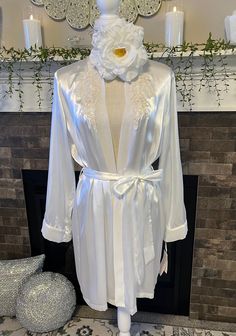 This luxurious short robe is designed to make you feel exquisite, whether you're lounging in elegance or preparing for a special evening. Its combination of sumptuous fabric, detailed craftsmanship, and romantic design elements creates a garment that is both breathtaking and unforgettable. More details about this piece.  Tag has price tag with $68 with color as "Ivory" but it's more of a white as listed.  Attached Tie Sash  Chiffon trim on sleeves  Floral Pearl and clear sequins appliqué on each Elegant Wrap Sleepwear, Elegant Open Front Sleepwear, Elegant Open Front Sleepwear For Loungewear, Elegant Fitted Wrap Robe, Elegant Robe For Wedding Night In Spring, Elegant Long Sleeve Sleepwear For Wedding Night, Elegant Spring Sleepwear For Wedding Night, Elegant Spring Wedding Night Robe, Elegant Spring Wedding Robe