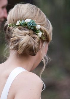 a man and woman standing next to each other with flowers in their hair on their heads