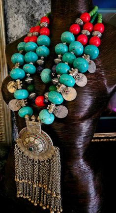 Here's a very bold, chunky and heavy tribal - ethnic chest piece that is not for the faint of heart!! Red, blue and green magnesite beads form the bulk of this piece along with a few carved emerald and sapphire beads. Silver tone stamped tribal bi-cones and vintage Kuchi coins are also featured which give additional drama and interest. A huge architectural Waziri pendant with inlaid glass is the focal point on this piece and measures 9" x 4". The innermost strand adjusts from 23-25" and I can add more chain links, if requested. Closes with an xl fancy gunmetal toned lobster claw clasp. From the Atelier of Kat Kouture! (This is quite heavy so please know your tolerance before you purchase). Traditional Turquoise Necklace With Natural Stones For Festivals, Artisan Turquoise Necklace For Festivals, Bohemian Turquoise Necklaces For Rituals, Bohemian Turquoise Necklace With Natural Stones For Festivals, Artisan Turquoise Necklace With Large Beads For Festival, Traditional Turquoise Necklace With Round Beads For Festival, Traditional Multicolor Turquoise Necklace For Festival, Handmade Artisan Turquoise Necklace For Festivals, Handmade Traditional Turquoise Necklace For Festivals