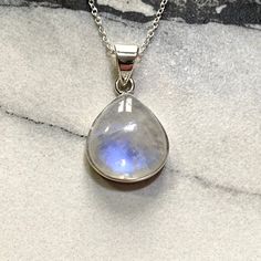 This beautiful Moonstone Pendant is set in Sterling Silver, stamped 925.  The moonstone is around 25x22mm in size suspended on a silver chain which adjusts from 16-18inches, perfect for any necklines. The Rainbow Moonstone has a beautiful blue flash which appears as the light catches it.  Each piece of Jocale Jewellery comes in a beautiful box making it the ideal gift! Natural Rainbow Moonstone, Real Moonstone, Moonstone Necklace, Blue Pendant, Stylish Jewellery, Affordable Jewellery, Moonstone Jewelry, Moonstone Jewellery, Blue Jewelry, White Jewellery, Blue Flash, June Birthstone  **Note From Our Gemmologist- Marie Chalmers ** Moonstone is a beautiful gemstone which shows a flash of blue as the stone moves called a schiller. This will happen in two orientations so our moonstone has been Moon Phase Pendant Necklaces For Anniversary, Sterling Silver Moon-shaped Jewelry For Anniversary, Celestial Silver Jewelry With Cabochon, Moon-shaped Moonstone Jewelry In White Gold, Silver Celestial Jewelry With Cabochon, Sterling Silver Moon Charm Necklace For Anniversary, Sterling Silver Necklaces With Moon Charm For Anniversary, Spiritual Moonstone Jewelry For Anniversary, Sterling Silver Necklace With Moon Charm For Anniversary