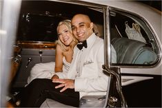 a man and woman sitting in the back of a car