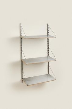 three metal shelving shelves on the wall