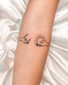 a woman's arm with two hands holding the sun and moon tattoo on it