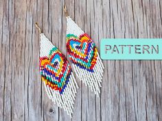 a pair of colorful beaded earrings sitting on top of a wooden table