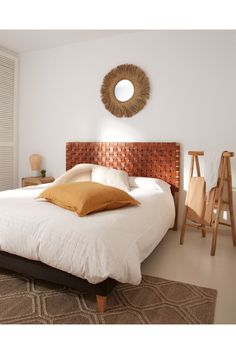 a bed with white sheets and brown pillows