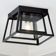 a light fixture hanging from the ceiling in a room with white walls and flooring