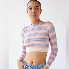 This Xs Urban Top Is A Stylish, Long-Sleeve Cropped Piece That Features A Vibrant Horizontal Stripe Pattern In Soft Pastels, Including Shades Of Pink, Blue, And White. The Ribbed Fabric Gives It A Textured Look, While The High Neckline Adds A Touch Of Sophistication. Perfect For Pairing With High-Waisted Jeans Or Skirts, This Top Combines A Playful Vibe With A Snug, Form-Fitting Silhouette, Making It Ideal For Casual Outings Or Layering Under Jackets. Multicolor Fitted Cropped Top, Striped Fitted Tops For Fall, Fitted Striped Tops For Fall, Multicolor Fitted Crop Top With Crew Neck, Fitted Multicolor Crop Top With Crew Neck, Striped Crop Top For Spring, Spring Striped Crop Top, Fitted Multicolor Crop Top For Fall, Striped Stretch Crop Top