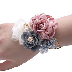 a woman's hand wearing a bracelet with flowers and pearls