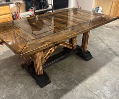 a wooden table with glass top sitting in a room next to a stove and cabinets