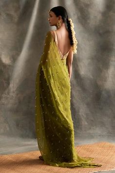 Olive green silk organza saree embellished with Swarovski crystals. Paired with a lampi blouse
Component: 2
Embroidered
Neckline: V Neck
Sleeve Length: Sleeveless
Fabric: Saree: Silk Organza; Blouse: Lampi; Lining: Cotton
Color: Green
Deep back
Plunging neck - Aza Fashions Olive Green Saree, Organza Saree With Blouse, Green Sari, Organza Blouse, Saree Silk, Green Saree, Embroidered Neckline, Organza Saree, Organza Fabric