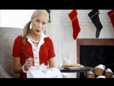 a woman is holding a bag with food on it in front of stockings hanging from the fireplace