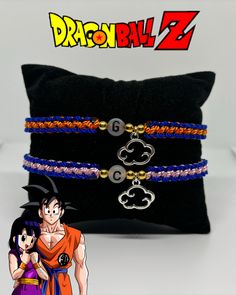 two bracelets with dragon ball characters on them and a pillow in the back ground