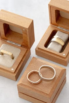 three wooden boxes with wedding rings in them