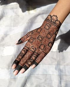 a woman's hand with henna tattoos on it