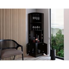 a black cabinet with wine glasses and bottles on it next to a chair in front of a window