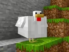 a white chicken standing on top of a green blocky ground next to a brick wall