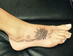 a woman's foot with a flower tattoo on it