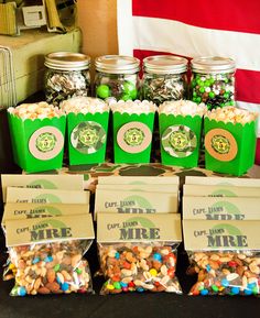 there are many small bags of candy in front of the flags and jars on the table