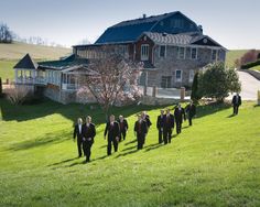 a group of men in suits walking down a hill