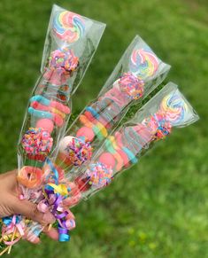 a person holding candy sticks in their hand with sprinkles and lollipops on them