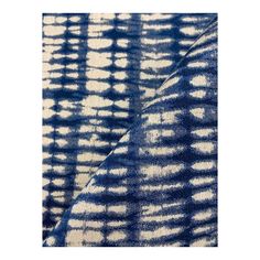 a blue and white tie dyed fabric with an uneven design on the front, in different shades