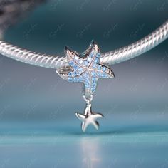 This is charm only, bracelet is sold separately.Experience the beauty of the ocean with our mesmerizing Blue Starfish dangle bead charm for a bracelet. This enchanting charm, crafted from solid 925 sterling silver and featuring a platinum platting and oxidation process, showcases a delicate starfish design with sparkling cubic zirconia and a charming little dangle. As you wear it, let the calming waves and limitless potential of the sea inspire your every step. Add a touch of elegance and marine Starfish Design, Blue Starfish, Sea Inspired, Beaded Dangles, Sterling Silver Charm, Silver Charms, Solid 925 Sterling Silver, Starfish, Bead Charms