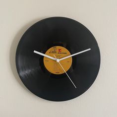 a black record clock hanging on the wall