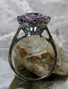 Natural Purple Amethyst Ring 100 Year Design#37 This is a brand new Edwardian reproduction filigree ring in antiqued solid sterling silver. The round full cut high-quality 5ct Natural Purple Amethyst gemstone is 12mm in diameter. The inside of the band is marked 925 for sterling. Notice the beautiful intricate crown-like design of the silver filigree setting and etched band. The original ring I bought in this exact design was from 1910. This is a rare and exact replica of that ring. A gift box i Heirloom Purple Amethyst Ring With Intricate Design, Art Nouveau Gemstone Jewelry For Wedding, Antique Wedding Rings With Round Stone, Victorian Style Purple Amethyst Ring For Anniversary, Art Deco Purple Amethyst Ring For Formal Occasions, Victorian Style Purple Amethyst Ring For Gift, Victorian Style Purple Amethyst Ring As Gift, Victorian Style Hallmarked Amethyst Ring, Purple Amethyst Art Deco Ring For Formal Occasions