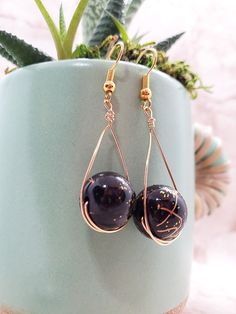 Black and gold colored swirled beads sit in a lovely drop setting. Black Beaded Teardrop Earrings For Gift, Teardrop Black Beaded Earrings As Gift, Teardrop Black Beaded Earrings For Gift, Teardrop Earrings With Black Beads For Gifts, Gold Beaded Teardrop Earrings For Gift, Wire Wrapped Teardrop Earrings For Party, Teardrop Gold Beads Earrings For Party, Teardrop Gold Beads Jewelry For Party, Gold Beads Teardrop Earrings For Party