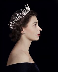 an old photo of a woman wearing a tiara and looking off into the distance