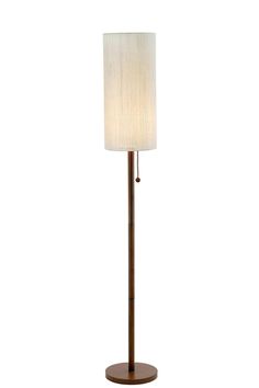 a floor lamp with a white shade on it's side and a wooden base