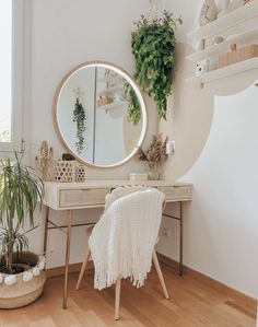 a room with a desk, mirror and potted plants on the wall next to it