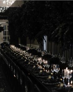 a long table is set with candles and plates for formal dinner guests to sit at