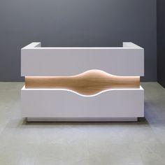 a modern white and wood reception table in an office building or conference room with grey walls