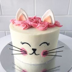 a white cake with pink frosting and ears on top