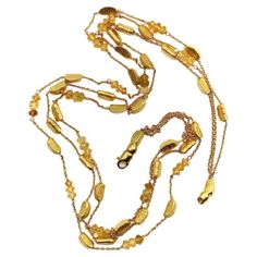 This 18k gold necklace consists of three strands of alternating gold bars and citrine briolette beads suspended between delicate gold chain. The shapes in this necklace are reminiscent of gold nuggets: the bars are moon-shaped wedges with a textured surface, while the citrine briollete beads are matched perfectly to the warm, buttery 18k gold, almost appearing to be made of gold as well. The two exterior strands contain both gold bars and citrine beads, while the center strand consists of only g Lingot D'or, Gold Bars, 18k Gold Necklace, Citrine Beads, Gold Nugget, Gold Bar, Multi Strand Necklace, Strand Necklace, Multi Strand