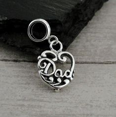 "This Dad Heart Charm comes with a silver dangle bead as pictured.   Fits on all major brand European style bracelets. A list of compatible chains is available here: https://etsy.me/2BY7DAW { DETAILS } ★ Charm Metal: 925 Sterling Silver ★ Bead Metal: Stainless Steel ★ Finish Color: Silver ★ Charm Size: 3/8\" x 5/8\" ★ Style: One-sided ★ Attachment: 5mm diameter large hole bead ★ Available without bead attached upon request Photo is not to scale and may appear larger to show detail. Refer to exac Silver Sterling Silver Charm Bracelet For Mother's Day, Silver Sterling Mother's Day Charm Bracelet, Mother's Day Silver Sterling Charm Bracelet, Silver Dangling Charms For Mother's Day, Mother's Day Silver Dangling Charms, Silver Charms For Jewelry Making On Mother's Day, Father's Day Silver Charms Jewelry, Sterling Silver Charm Bracelet For Mother's Day, Silver Heart Beads Dangle Jewelry