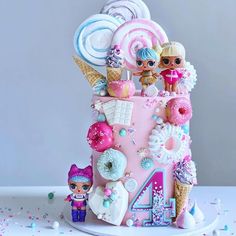 a pink birthday cake decorated with lollipops, marshmallows and candies