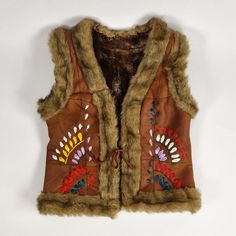 Sleeveless Winter Vest For Festivals, Bohemian Sleeveless Outerwear For Winter, Winter Festival Outerwear Vest, Brown Sleeveless Vest With Faux Fur Lining, Embroidered Sleeveless Outerwear For Winter, Bohemian Brown Winter Vest, Winter Bohemian Brown Vest, Brown Bohemian Winter Vest, Boho Vest