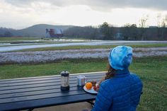 a person sitting at a picnic table with food