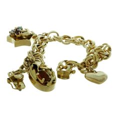 This classic vintage link bracelet is crafted in 14k yellow gold and features 3 charms - a heart charm (with some dents and fine scratches), a star charm prong-set with 3 faceted gemstones, and an oval charm prong-set with a yellow-orange citrine. Made in United States circa 1970s. Measurements: 0.35" (9mm) width, 8.25" (20.9cm) length. Pre-owned. Shows some normal signs of wear. Comes in an unbranded gift box. Gold Flower Bracelet, Orange Citrine, Vintage Charm Bracelet, Jaune Orange, Wide Bracelet, Gold Charm Bracelet, Handcrafted Bracelets, Bezel Set Diamond, Yellow Gold Bracelet