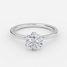 a round brilliant cut diamond engagement ring on a plain white background, with the center setting in