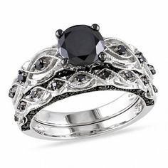 On the day you ask for her hand in marriage, express your love with this bold and elegant black diamond bridal set. Crafted in 10K white gold The engagement ring features a 1 ct. black diamond center stone. The shank features sculpted and milgrain detailing and additional black diamonds while additional black diamonds set at the top and bottom of the shank ensure sparkle from every angle. On your wedding day, the coordinating black diamond wedding band completes the ensemble. This bridal set shi Swirl Engagement Ring Set, Black Diamond Bridal Set, Swirl Engagement Rings, Black Diamond Wedding Rings, Black Diamond Wedding Bands, Gothic Engagement Ring, Infinity Engagement Ring, White Gold Bridal Set, Infinity Wedding