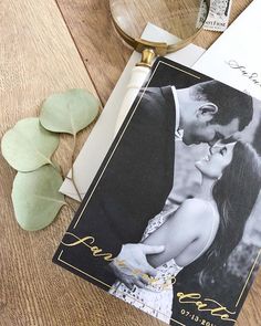 a couple kissing on the forehead next to an envelope and some paper with gold foil