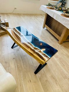 a wooden table sitting on top of a hard wood floor next to a white couch