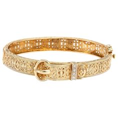 Stylish and finely detailed vintage buckle bracelet crafted in 14 karat yellow gold. Four diamonds total an estimated 0.08 carats 9estimated at H-I color and VS2-SI1 clarity). The bangle features an elaborate design of scrolled and paneled foliated details. The buckle design represents the joining of two lives together. The bracelet is great worn alone as a statement piece or layered with your fine jewelry from any era. The bracelet will fit a smaller sized wrist (6 inches). Please check your wr Opal Bangle, Modern Bangle, Yellow Gold Bangle, Art Deco Bracelet, Buckle Bracelet, Gold Bangle Bracelet, Bracelet Bangle, Vintage Diamond, Gold Bangles