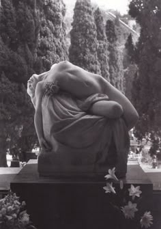 a black and white photo of a woman with her head in the back of a statue