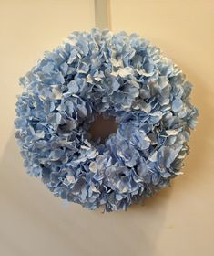 a blue wreath hanging on the wall with no one around it or in front of it