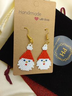 a pair of earrings with santa clause on them